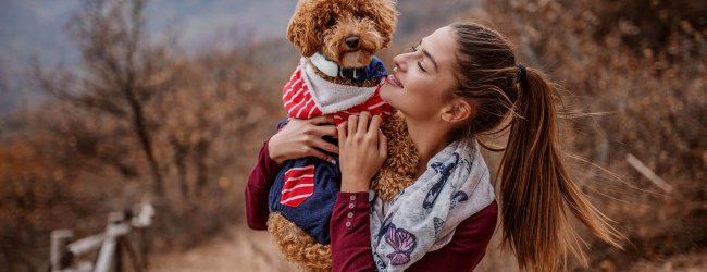 woman and dog wearing GPS tracker outside posing