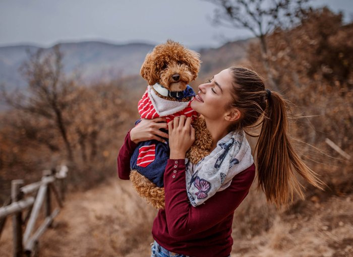 woman and dog wearing GPS tracker outside posing