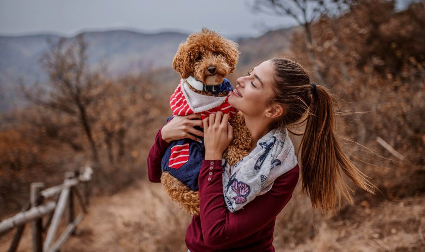 woman and dog wearing GPS tracker outside posing