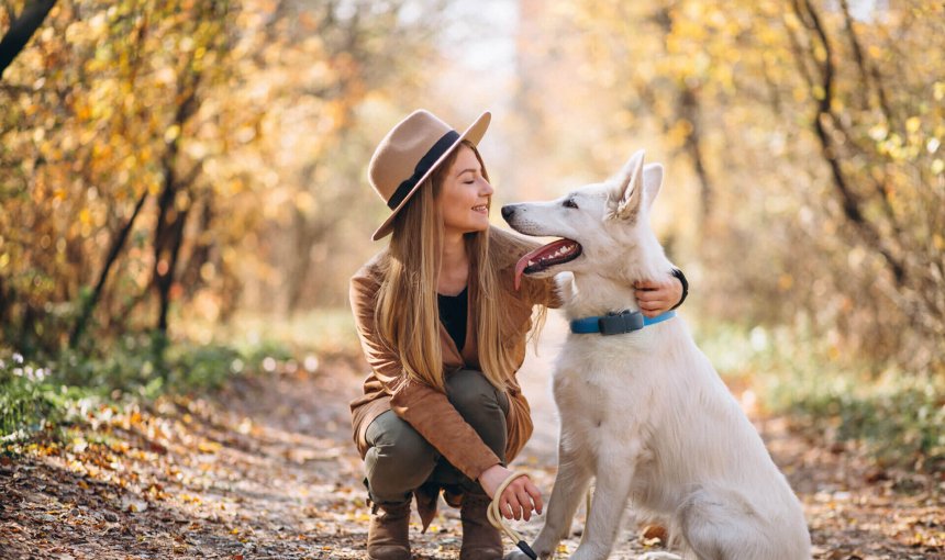 Kvinde i skov med hund med bluetooth GPS-tracker fra Tractive