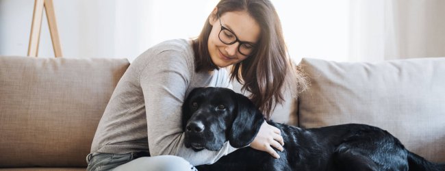 young woman with black dog on couch