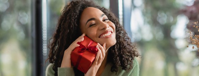 woman holding small red gift-wrapped present