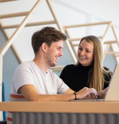 Man and woman sitting next to each other and laughing