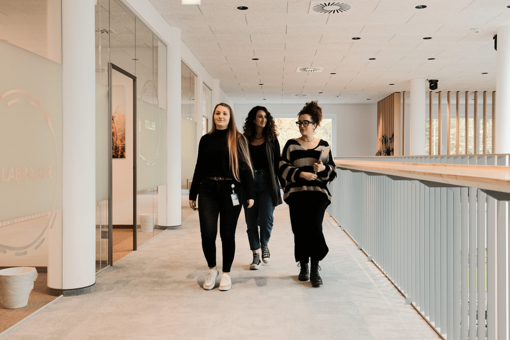 three women walking in an office building